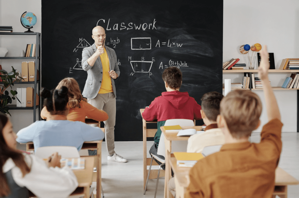 A classroom of kids, with a teacher.